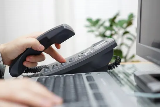 customer service dialling a phone number in office