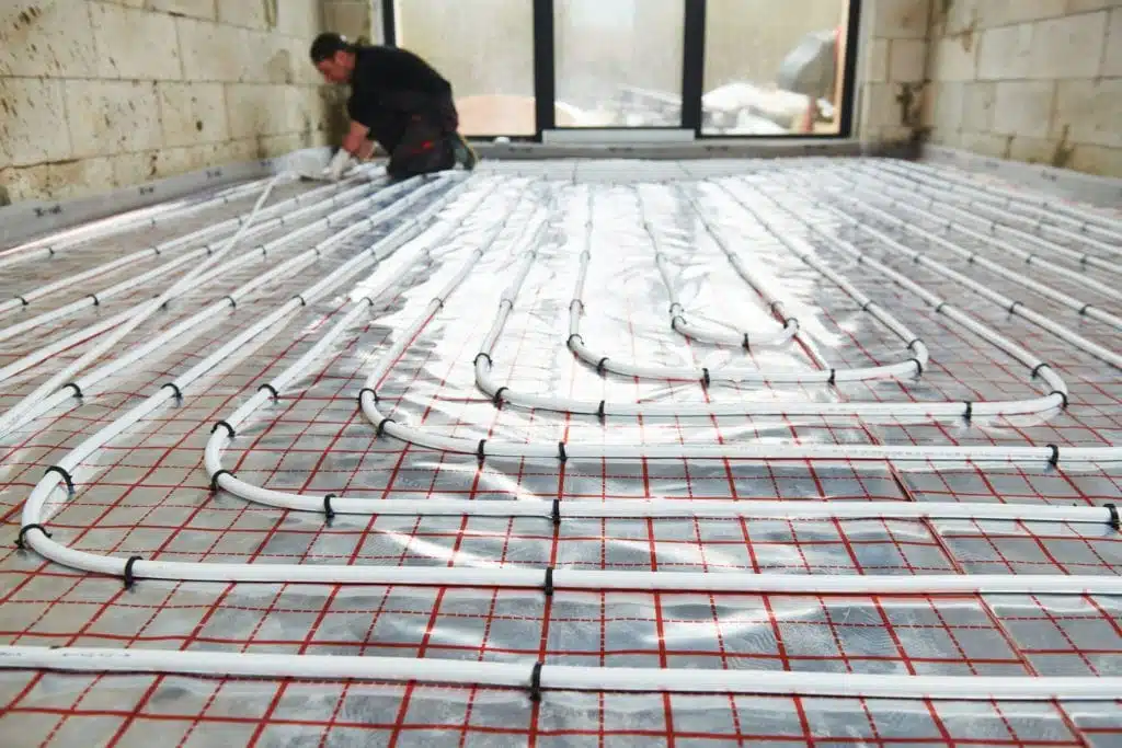 Close up for wet underfloor heating (UFH) pipe being installed.